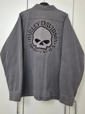 Grå Harley-Davidson skjorta XL - Rare Harley Davidson jacket, vintage style from 2012. One button missing but still functions on the back. It has a nice oversized fit with 52 cm over shoulders and 46 across the chest. More photos can be sent if wanted.