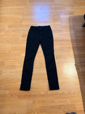 Svarta jeans Tiger of Sweden - Snygga svarta jeans från Tiger of Sweden. Klassisk femficksmodell med smal passform och hög midja. Perfekta till både sneakers och boots. Materialet känns mjukt och stretchigt för extra komfort.