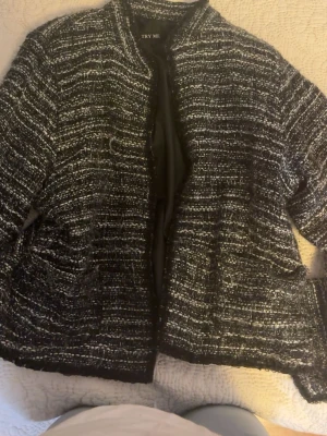 cardigan från TRY ME - Asnygg svartvit bouclé cardiganjacka från TRY MEdom har knappar inuti för att stänga. Jackan två fickor framtill och passar med lager på lager eller över en basic outfit.