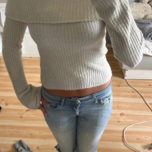 Ljusbeige ribbad offshoulder tröja - Superfin ljusbeige ribbad tröja med offshoulder-design och långa ärmar. Tröjan är croppad och sitter tajt, perfekt till jeans eller kjol. Mjuk och stretchig, passar dig som gillar en stilren och trendig look. I strl xs och säljer pga att ja inte använder den mer, lite nopprig nertill