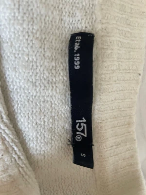 Vit stickad tröja från 157 - Snygg vit stickad tröja från 157 med rund halsringning och ribbade muddar. jag tycker själv jag ej passar tröjan det är anledningen till att jag säljer, skriv om frågor eller fler bilder