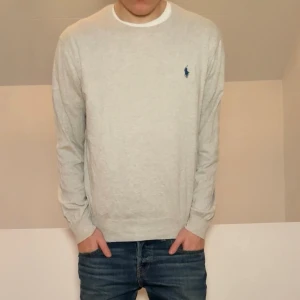Ralph Lauren ljusgrå tröja  - Säljer en sjukt fet tröja från Ralph Lauren i färgen ljusgrå. Tröjan är i bra skick då den har varit väl omhändertagen, förutom att nacklappen tyvärr har trillat av. Tröjan är i strl M och sitter även som M. Hör gärna av er vid frågor elr funderingar!!