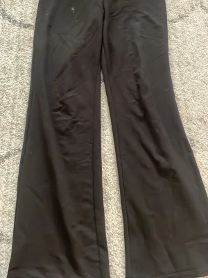 Svarta utsvängda mjukis byxor - Säljer ett par svarta mjukisbyxor med utsvängda ben. De har en hög midja och är tillverkade i ett stretchigt material som sitter skönt på kroppen. Perfekta för en avslappnad och trendig look.