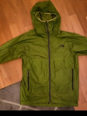 Grön vindjacka från The North Face - Jättefin och sällsynt, pyttehål och pyttefläk som inte märks av se markeringar storlek S 