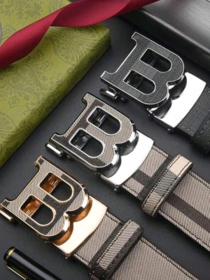 Burberry bälte  - Snyggt bälte från Burberry med stort B-format metallspänne. Bältet har ett randigt mönster i olika nyanser av svart, grått och beige. Tillverkat i skinn med detaljer i metall, perfekt för att lyfta din outfit.