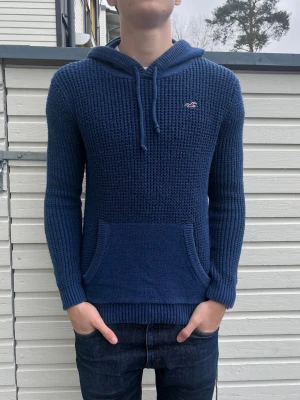 Hollister stickad hoodie - Tja! Säljer nu denna sjukt snygga stickade Hollister hoodie. Skick 10/10  utan defekter! Modellen är 182 och väger 70kg men passar allt mellan 175-185. Hör av er vid frågor!
