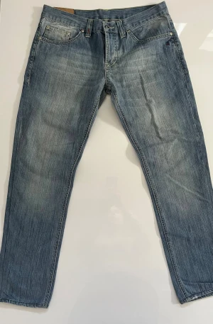 Dondup jeans - Säljer ett par ljusblå dondup jeans med raka ben och diskreta slitningar. Jeansen har klassisk femficksdesign, normal midja och är tillverkade i denim. Perfekta för en avslappnad och trendig look.