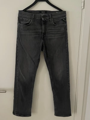 Replay jeans - Tjabba säljer ett par Snygga svarta jeans från Replay med raka ben och klassisk femficksmodell. Jeansen har diskreta slitningar och detaljerade sömmar på bakfickorna. Tillverkade i mjukt denimtyg som ger en bekväm passform. Modellen är thad och storlek finns tydligen inte av någon anledning då de inte finns någon storleks tagg men skulle gissa på Xs-S, skriv om du vill ha mått!! Skicket är 8,5/10 se bild!! Hör av dig vid mer frågor eller funderingar🕺mvh Ga🤩😁