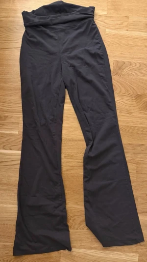 Folded yoga pants Gina Tricor - Grå leggings med hög midja och utsvängda ben. Mjukt och stretchigt material som sitter bekvämt och följer kroppen. Perfekta för en avslappnad och trendig stil.