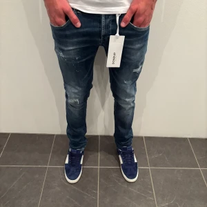 Dondup Jeans George  - Dondup Jeans George! Trendigaste jeansen på marknaden.  Skick= 8/10 (använda ett fåtal gånger men hål i skrevet bild kan fås om man frågar) Ny pris= 4000 kr Säljs för= 799 kr (Modellen har original slitningar från fabrik vilket är väldigt eftertraktat och populärt)