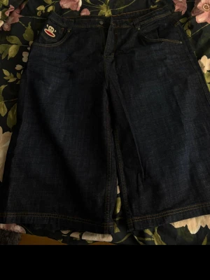 Mörkblå denimshorts Paul Frank - Paul Frank jorts från jaded london. Älskar the baggy fit men dessa är lite för stora för mig. Aldrig haft på mig dom ute. Har bara testat dom. Denna collection går inte att köpa längre. Jag köpte dom för 900kr. Så de mer än 50% på priset. 