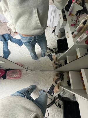 Ljusblå jeans från Gina Tricot  - Säljer ett par ljusblå jeans som är superlågmidjade, utsvängda och har slitna detaljer på låret och knät. 