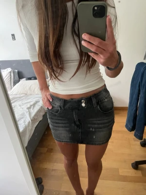 Svart jeanskjol  - Säljer en svart jeanskjol i kort modell med dubbla knappar framtill och fickor. Kjolen har en lätt tvättad look❣️