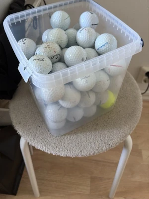 Stort parti golfbollar i blandade färger - Säljer en stor låda med golfbollar i olika färger och märken. De flesta är vita men det finns även gula, rosa och blå bollar. Några har mönster som ser ut som fotbollar. Perfekt för dig som vill fylla på golfväskan! Köp ej för priset skriv vid intresse