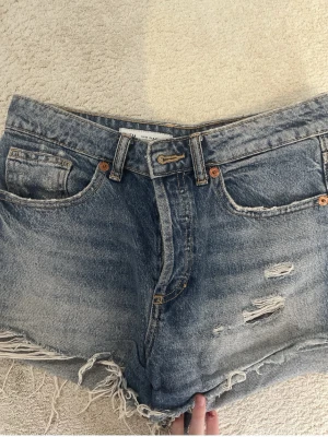 Blå jeansshorts med slitningar - Säljer ett par blå jeansshorts med slitningar från Zara, nästan aldrig använt💖