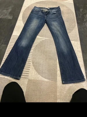 LTB jeans - Säljer ett par blå bootcut jeans från LTB med klassisk femficksmodell och snygga slitningar framtill. Jeansen har normal midja och utsvängda ben, vilket ger en retro och avslappnad vibe. Storlek:36-38 är jag säker på