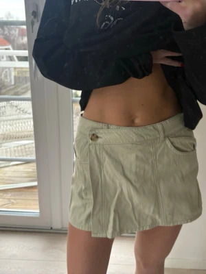 Khaki grön kjol - Trendig beige kortkjol med fickor både fram och bak. Kjolen har en knappdetalj i midjan och är som shorts där bak💚