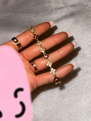 Armband - Ett jättefint guld armband som har vita i vinröda diamanter. Jag köpte den från raglady för 400kr . Den kom tyvärr aldrig till användning så det är varför jag säljer den❤️