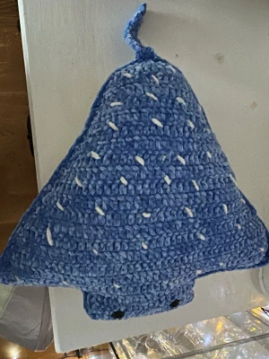 Blå virkad stingrocka kudde - Mysig kudde formad som en stingrocka, virkad i blått garn med vita prickar och svans. Kudden har svarta ögon och är mjuk och gosig, perfekt som dekoration eller gosedjur. Passar bra i soffan eller på sängen. 