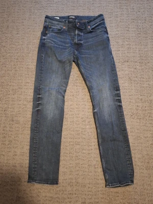 Mörk blåa jack & jones jeans - Säljer ett par mörk blåa Jack & Jones med passform comfort och klassisk femficksdesign, Storlek 28W 32L. Perfekta för dig som gillar en tidlös och enkel stil. Skrive vid frågor.