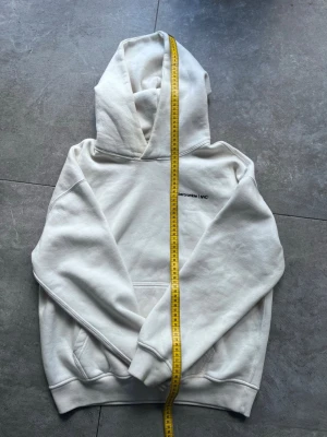 Abercrombie & Fitch "Soft A&F Essentials" Hoodie – XS – Nyskick - Klassisk och otroligt mjuk hoodie från Abercrombie & Fitch i färgen off-white/benvit. Modellen tillhör deras "Soft A&F Essentials"-linje och är känd för sin höga komfort och kraftiga kvalitet. Plagget är i nyskick utan anmärkningar. • Storlek: XS • Mått: Se bilder för exakta mått (Längd ca 68 cm, Bredd ca 53 cm). • Skick: Nyskick / Som ny.