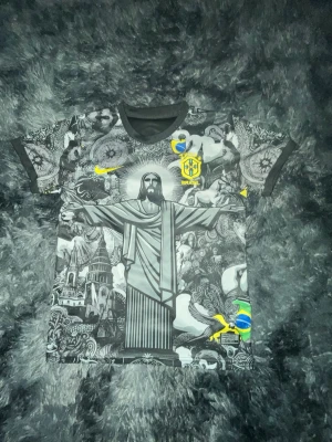 Brasilien Vini Jr. matchtröja och shorts svart - Säljer svart Brasilien matchtröja med shorts från Nike med Vini Jr. och nummer 7 på ryggen. Tröjan har ett unikt grafiskt mönster med Kristusstatyn och brasilianska symboler, samt gula detaljer och logotyp på bröstet. Perfekt för fotbollsfans!