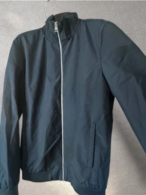 Vändbar jacka Elvine - Snygg mörkblå jacka med hög krage och dragkedja framtill. Jackan har två sidofickor och ribbade muddar vid ärmslut och nederkant. #elvine #jacka 