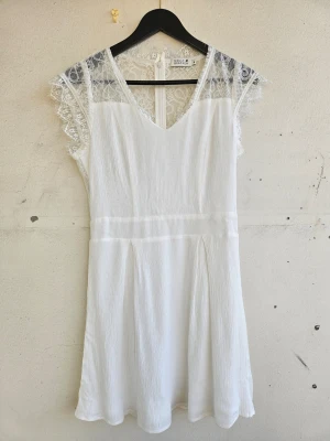 Studentklänning med spets - Superfin sommarklänning med spets över ryggen och spetsdetaljer framtill. Perfekt för studenten! Från Molly Bracken i storlek M, men ganska liten i storleken. Bara använd en gång.