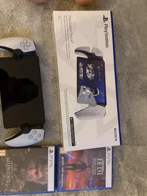 PlayStation Portal Remote Player - Helt ny och oanvänt. PlayStation Portal Remote Player från Sony, en bärbar spelkonsol med stor svart skärm och vita handkontroller på sidorna. Modern design med klassiska PlayStation-knappar och touchskärm. Perfekt för att streama PS5-spel trådlöst hemma.