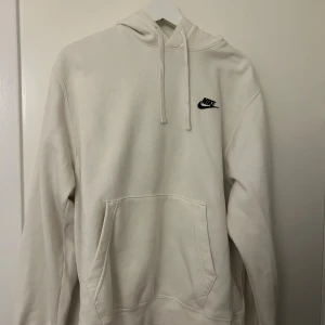 Vit hoodie från Nike med logga - Snygg vit hoodie från Nike med svart broderad logga på bröstet. Haft ett tag men använd fåtal gånger