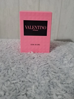Valentino Donna Born In Roma parfym - Valentino Donna Born In Roma är en lyxig parfym i en elegant glasflaska med nitar och svart lock. Förpackningen är rosa med svart etikett och tydlig logga. Doften är modern och feminin, perfekt för dig som vill sticka ut med en exklusiv signaturdoft.