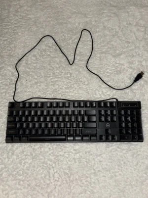 Svart USB-tangentbord - Ett svart tangentbord med numerisk del och USB-anslutning. Den lyser alla färger. Standardlayout med svenska tecken och funktionstangenter. Tillverkat i plast och passar till de flesta datorer med USB-port. Perfekt för gaming!