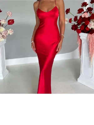 Balklänning - Säljer en röd, figurnära långklänning i satin med smala axelband och snygg snörning i ryggen. Jag köpte klänningen av en tjej på plick, så den har endast använts 1 gång. Jag är ca 161 och den går till fötterna på mig. Verkar vara någon fläck (se sista bilden) men har inte testat ta bort. kom privat för fler bilder💕