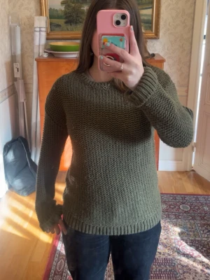 Olivgrön stickad tröja💕 - En olivgrön stickad tröja med grov struktur och rund hals. Tröjan har långa ärmar och ribbade muddar vid ärmslut och nederkant. 