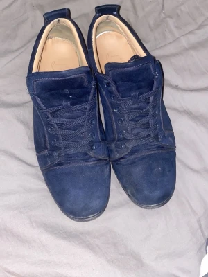 Mörkblå mockasneakers med låg profil - Priset går att diskutera! Stilrena sneakers i mörkblå mocka med matchande blå skosnören och låg siluett. Skorna har en klassisk design med rund tå och diskreta sömmar. Insidan är ljusbeige och sulan är svart. Perfekta för en clean och enkel look.