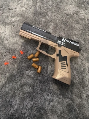 Leksakspistol  - Leksakspistol liknar en riktig men är inte, toppen är målad svart men är orange, du får med ett par 20 skott utav dem oranga man ser på bilderna.