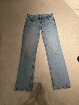 Ljusblå raka jeans - Säljer ett par ljusblå jeans med rak passform. Jeansen har normal midja och är tillverkade i denim. Perfekta för en avslappnad och trendig stil.