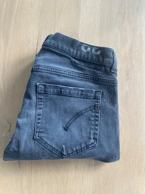 Dondup jeans - Snygga grå/svarta jeans från Dondup med klassisk femficksdesign och en slim passform. Jeansen har en diskret tvättad look och snygga slitningar . Perfekta för en stilren och modern look.