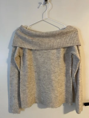 Beige off shoulder stickad tröja Gina Tricot - Säljer en beige stickad tröja från Gina Tricot med bred off shoulder-krage och ribbade muddar. Tröjan har lång ärm och är perfekt för dig som gillar en avslappnad men trendig stil. Materialet är mjukt och mysigt. Knappt använd så säljer lite dyrare men pris går att diskutera💕💕
