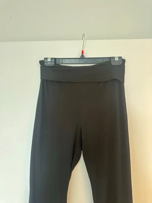 Svarta yoga pants  - Säljer ett par svarta yoga pants med bred linning i midjan. De är stretchiga och sitter skönt på kroppen, perfekta till en avslappnad look. Materialet känns mjukt