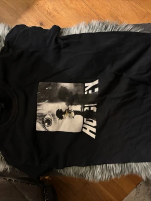 Svart Hockey  t-shirt med tryck - Cool svart t-shirt från Hockey med ett stort grafiskt tryck i vitt och grått framtill. Klassisk passform och rund halsringning. Perfekt för dig som gillar streetwear och vill ha en unik look.