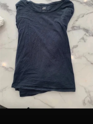 Mörkblå långärmad topp 157 - En enkel och stilren mörkblå långärmad topp från 157. Toppen har rund halsringning och är tillverkad i mjuk bomull, perfekt för en clean och avslappnad look.