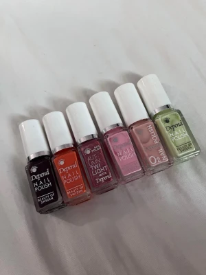 6-pack nagellack från Depend - Säljer ett set med sex nagellack från Depend i olika färger: mörklila, orange, vinröd, ljusrosa, nude och ljusgrön. Flaskorna är små och har vita lock. Perfekt för dig som vill variera din nagellook med både matta och glansiga finishar.