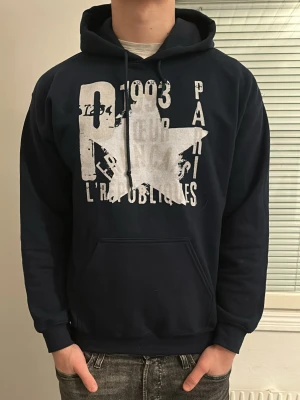 Mörkblå hoodie med tryck - Riktigt snygg hoodie som jag säljer då den var en aning liten för mig. Skick 9/10 nypris 649kr mitt pris 399kr. Modellen är 181. Hör av dig om du har några frågor!