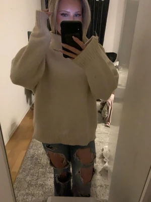 Stickad tröja - En oversized beige stickad polotröja med breda ärmar och ribbade muddar. Tröjan har en hög krage och är gjord i ett mjukt material som passar perfekt för kalla dagar. Enkel och stilren design som är lätt att matcha med ett par snygga jeans 🥰