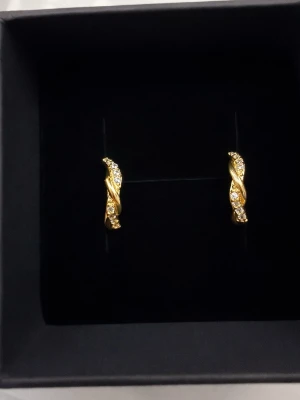 Guldpläterade 925 sterling silver örhängenmed stämpel - Helt nya guldpläterade örhängen i 925 sterling silver med gnistrande stenar. Elegant tvinnad design som passar både till vardag och fest. 🌸