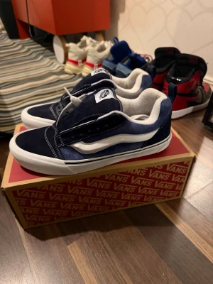 Marinblå Vans Old Skool sneakers - Säljer ett par klassiska Vans Old Skool sneakers i marinblå mocka och canvas med vit sula och ikonisk vit sidostripes. Skorna har lågt skaft och vit innersida. Perfekta för dig som gillar streetwear och skate-stil.