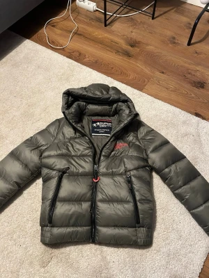 Grön pufferjacka från Superdry - Grön pufferjacka från Superdry. Jackan är i storlek S och har aldrig använts. 