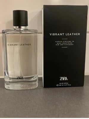 Zara Vibrant Leather Eau de Parfum - Zara Vibrant Leather Eau de Parfum i en stilren, transparent glasflaska med svart lock. Doften kommer i en svart, elegant kartong och flaskan rymmer 150 ml. Minimalistisk design med tydlig logga och text på både flaska och förpackning.