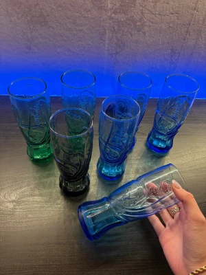 Unika Coca-Cola glas 7-pack - Säljer klassiska Coca-Cola-glas i fint skick. Perfekta för samlare eller för dig som vill servera dryck med en retro-känsla. Glasen har den ikoniska Coca-Cola-designen och passar lika bra till vardags som till fest.  ✔ Fint skick ✔ Klassisk design ✔ Perfekta för samlare eller Coca-Cola-älskare  Kan hämtas eller skickas ⭐️